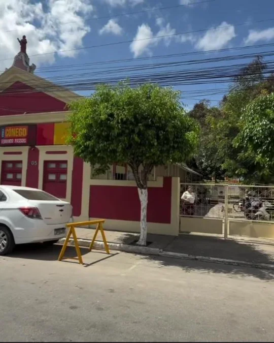 Fachada da Escola Cônego Fernando Passos, no Centro de Limoeiro, com o letreiro e as árvores da calçada
